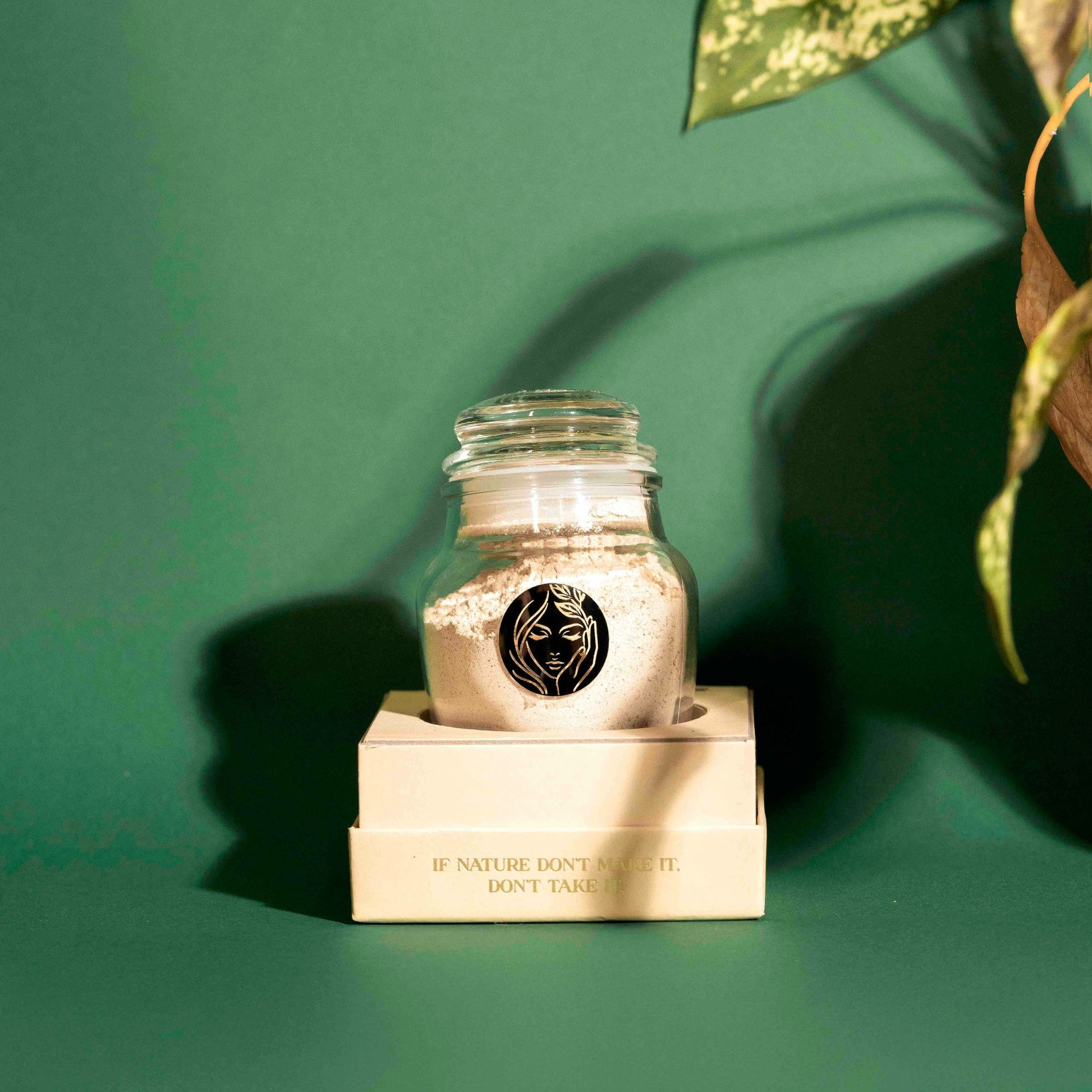 Prakriti's All Natural Face Pack Ubtaan displayed clearly in a box against a grainy texurous green background with some blurred leaves on the top