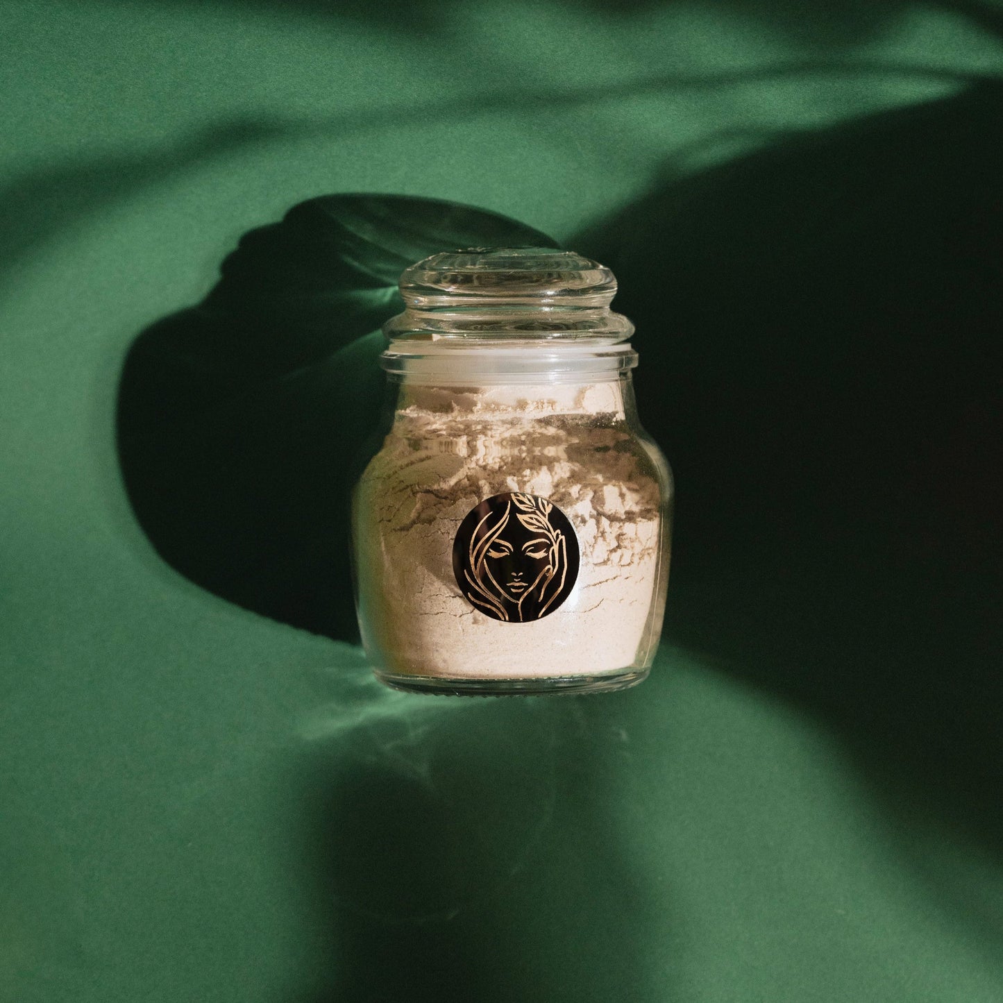 Organic Ubtaan Face Pack By Prakriti dramatically displayed against a green grainy backdrop with a clear prakriti logo visible in the front. 