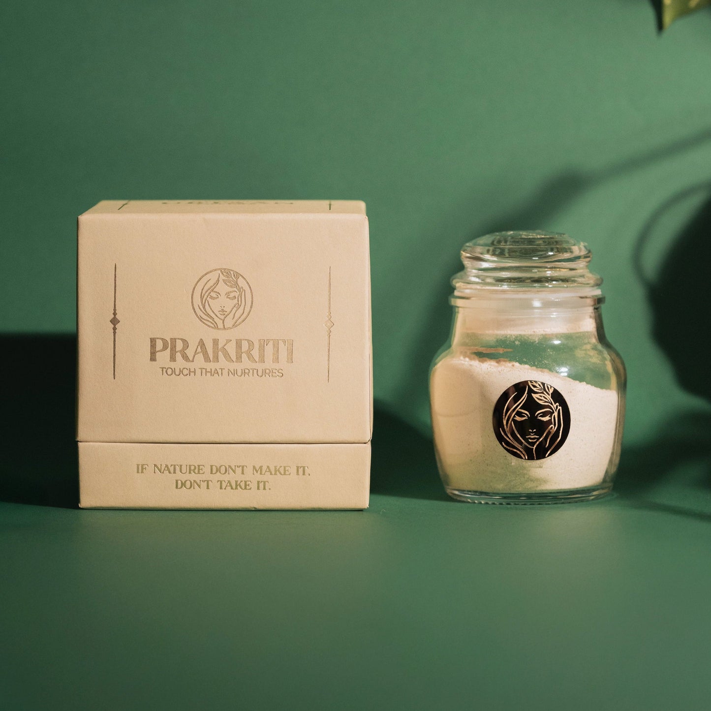 Prakriti's All Natural Face Pack Ubtaan displayed clearly in a box against a grainy texurous green background with some blurred leaves on the top